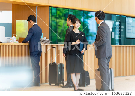 An usher woman serving tourists at the front desk An usher woman serving tourists at the front desk 103653128