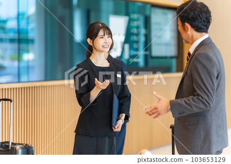 An usher woman serving tourists at the front desk An usher woman serving tourists at the front desk 103653129
