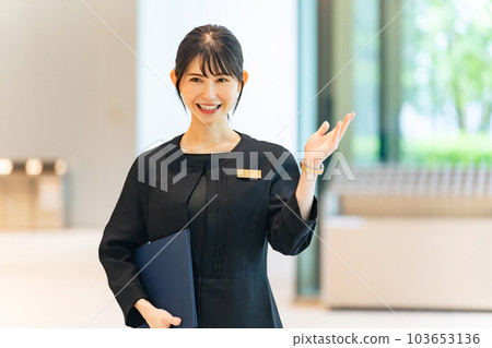 Woman guiding in lobby 103653136