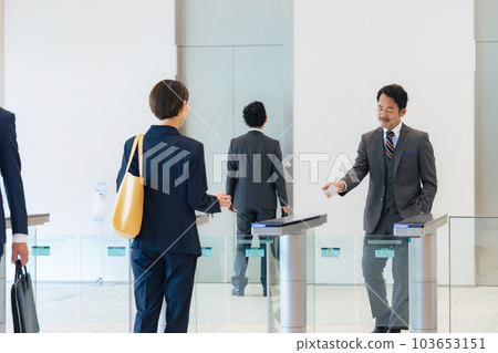 A group of business people passing through the entrance/exit gate Office security 103653151
