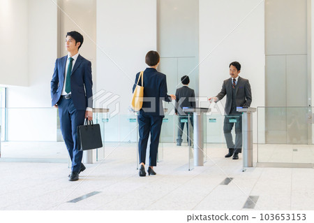 A group of business people passing through the entrance/exit gate Office security 103653153