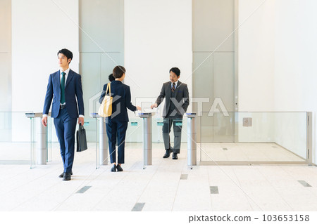 A group of business people passing through the entrance/exit gate Office security 103653158