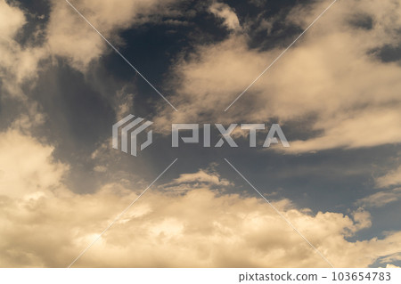 Background of the evening sky at sunset with white fluffy clouds. Background of the evening sky at sunset with white fluffy clouds. 103654783