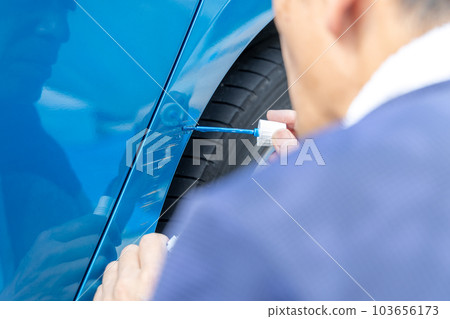 中年男子試圖自己修復汽車上的划痕 103656173