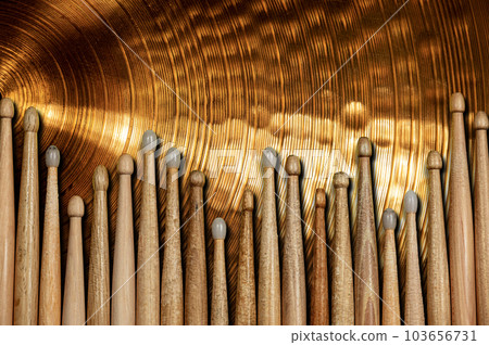 Group of Wooden Drumsticks on a Golden Cymbal 103656731