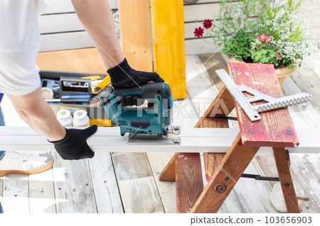 Man working with a jigsaw for DIY 103656903