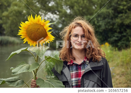 Girl posing for a photo with sunflower 103657256