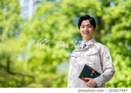 一位工程師帶著新鮮的綠色中型筆記本走路 103657467