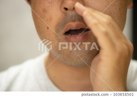 一個男人用手放在嘴上偷偷說話 一個男人用手放在嘴上偷偷說話 103658501