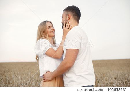 Cute couple in a field. Lady in a white blouse. Guy in a white shirt 103658581