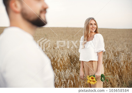 Cute couple in a field. Lady in a white blouse. Guy in a white shirt Cute couple in a field. Lady in a white blouse. Guy in a white shirt 103658584
