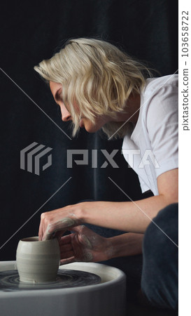 ceramist works behind a potter's wheel ceramist works behind a potter's wheel 103658722