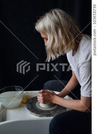 ceramist works behind a potter's wheel  103658730