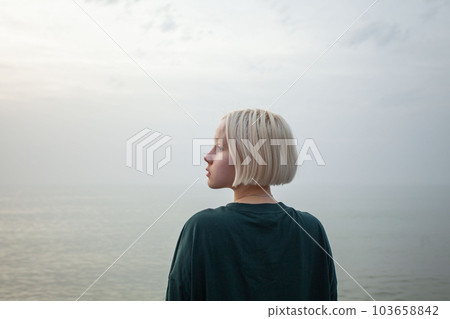 Pretty young adult woman with short blonde hair outdoor portrait Pretty young adult woman with short blonde hair outdoor portrait 103658842