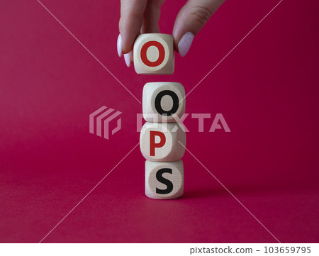 Oops symbol. Concept word Oops on wooden cubes. Businessman hand. Beautiful red background. Business and Oops concept. Copy space. 103659795