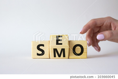 SEO vs SMO symbol. Businessman hand points at wooden cubes with words SMO to SEO. Beautiful white background. SEO vs SMO and business concept. Copy space 103660045