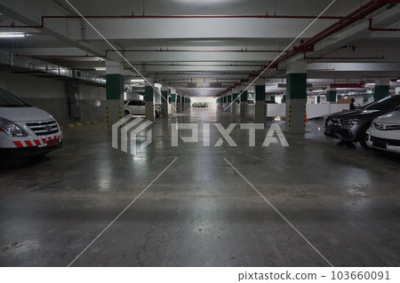 Photo of car and motorbike parking in the basement of a building, late afternoon 103660091