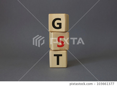 GST - Goods and Services Tax symbol. Concept word GST on wooden cubes. Beautiful grey background. Business and GST concept. Copy space. 103661377