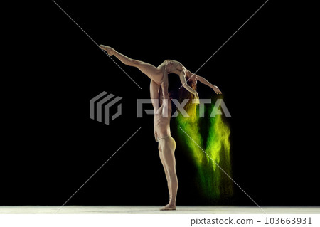 Attractive, talented, young man and woman, ballet dancers making colorful performance with powder explosion against black studio background 103663931