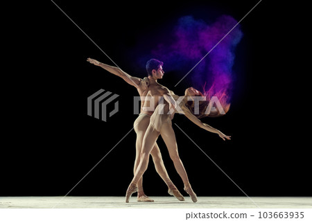 Graceful, beautiful couple, man and woman, ballet dancers performing against black studio background with colorful power explosion Graceful, beautiful couple, man and woman, ballet dancers performing against black studio background with colorful power explosion 103663935