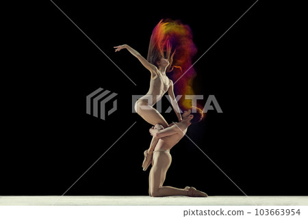 Expressive dance. Young man and woman, ballet dancers making performance with powder explosion against black studio background Expressive dance. Young man and woman, ballet dancers making performance with powder explosion against black studio background 103663954