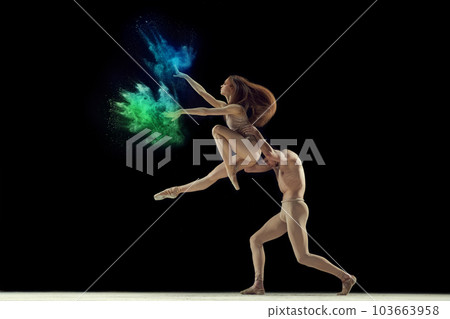 Artistic young man and woman, talented ballet dancers in beige bodysuits dancing with colorful powder explosion against black studio background Artistic young man and woman, talented ballet dancers in beige bodysuits dancing with colorful powder explosion against black studio background 103663958