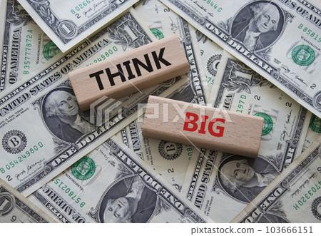 Think big symbol. Wooden blocks with words Think big. Beautiful dollar background. Business and Think big concept. Copy space. Think big symbol. Wooden blocks with words Think big. Beautiful dollar background. Business and Think big concept. Copy space. 103666151