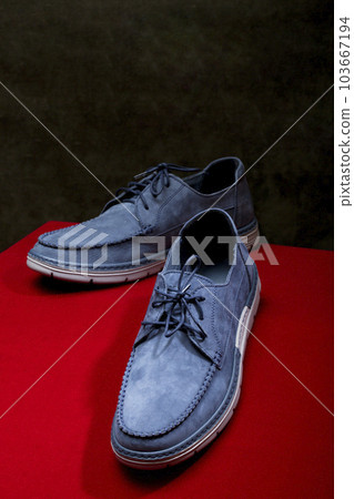 Blue leather men's shoes on the red table 103667194