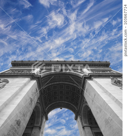 Arc de Triomphe (against the background of sky with clouds), Paris, France. The walls of the arch are engraved with the names of 128 battles and names of 660 French military leaders (in French) 103667714