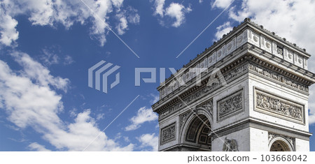 Arc de Triomphe (against the background of sky with clouds), Paris, France. The walls of the arch are engraved with the names of 128 battles and names of 660 French military leaders (in French) 103668042