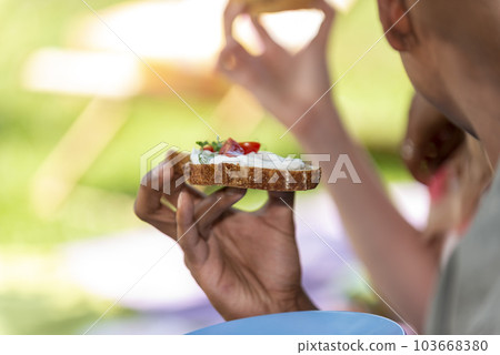 man is holding an appetizer in his hand 103668380
