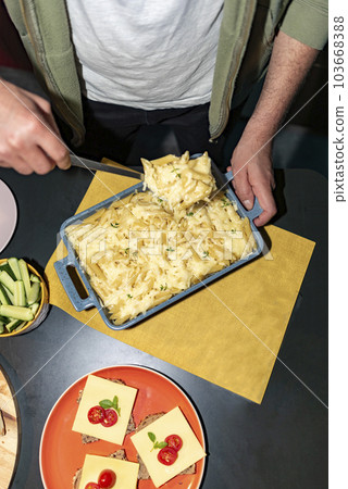 Man serving pasta with a spoon 103668388