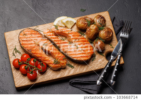 Grilled salmon steaks and potatoes 103668714