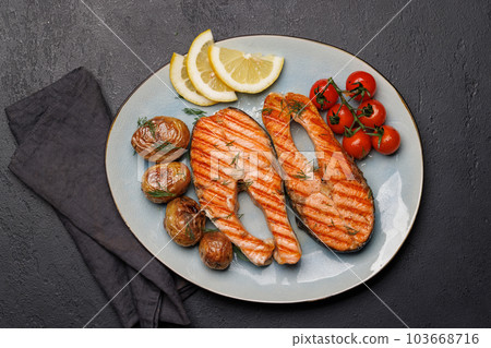 Grilled salmon steaks and potatoes Grilled salmon steaks and potatoes 103668716