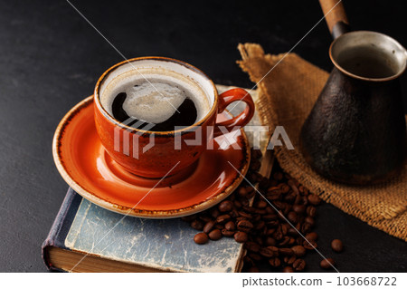 Rich coffee in a cup with aromatic roasted beans 103668722