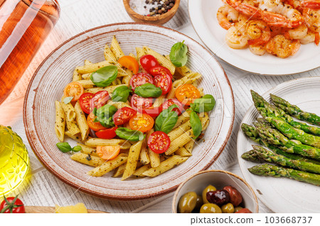 Italian pasta adorned with fresh tomatoes and aromatic basil 103668737