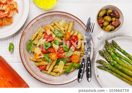 Italian pasta adorned with fresh tomatoes and aromatic basil 103668739
