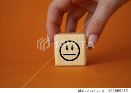 Neutral smile symbol. Neutral smile on wooden cubes. Businessman hand. Beautiful orange background. Business and Neutral smile concept. Copy space. 103669985