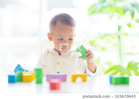 Baby boy playing with toy Baby boy playing with toy 103670643