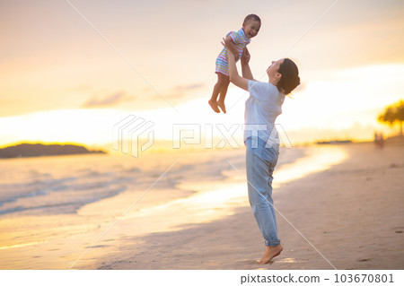 Mother and baby on tropical beach at sunset. 103670801