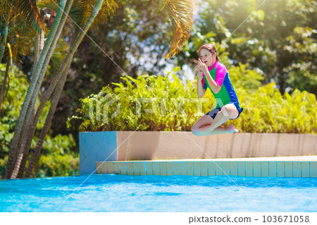 Kids jump into swimming pool. Summer water fun. Kids jump into swimming pool. Summer water fun. 103671058
