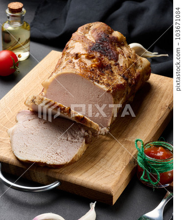 Baked piece of pork balyk on the table with spices. Tenderloin cut into pieces Baked piece of pork balyk on the table with spices. Tenderloin cut into pieces 103671084