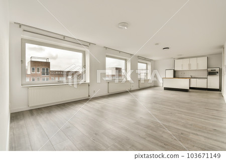 an empty living room with wood flooring and white cabinetd appliances on the windows overlooking out onto the street an empty living room with wood flooring and white cabinetd appliances on the windows overlooking out onto the street 103671149
