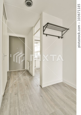 an empty room with white walls and wood flooring, there is a door leading to the left side of the room an empty room with white walls and wood flooring, there is a door leading to the left side of the room 103671185
