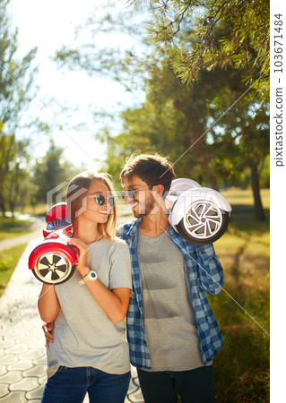 Young man and woman riding on the Hoverboard in the park. content technologies. a new movement. 103671484