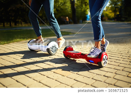 Young man and woman riding on the Hoverboard in the park. content technologies. a new movement. 103671525