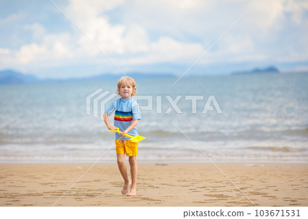 Kids play on tropical beach. Sand and water toy. 103671531