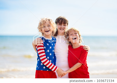 Kids with American flag on beach. 4th of July. Kids with American flag on beach. 4th of July. 103671534