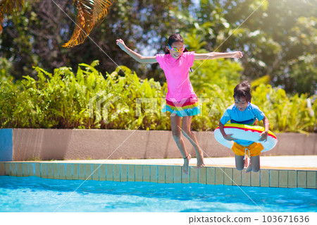 Kids jump into swimming pool. Summer water fun. Kids jump into swimming pool. Summer water fun. 103671636