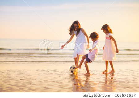 Kids play football on tropical beach at sunset 103671637